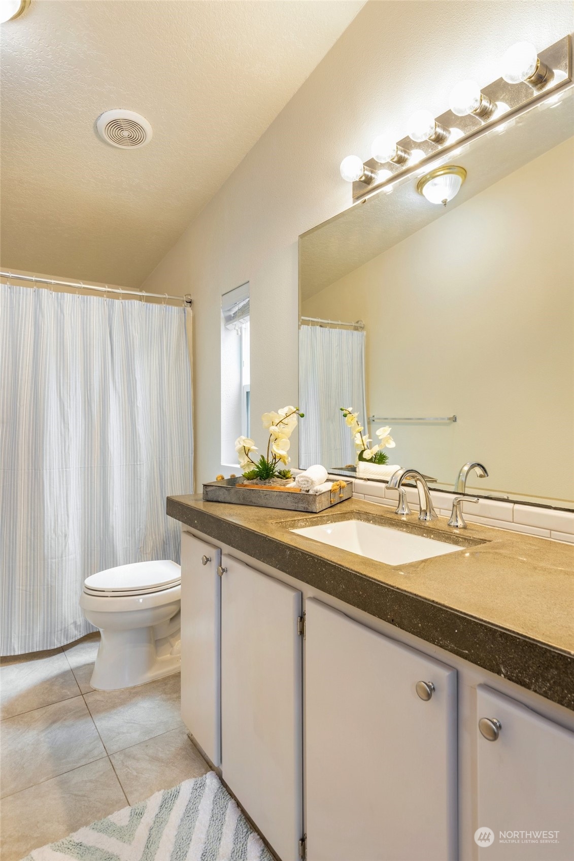 7942 Crockett Road Blaine, WA 98230 - Photo 21 of 33 a bathroom with a granite countertop sink toilet and a mirror