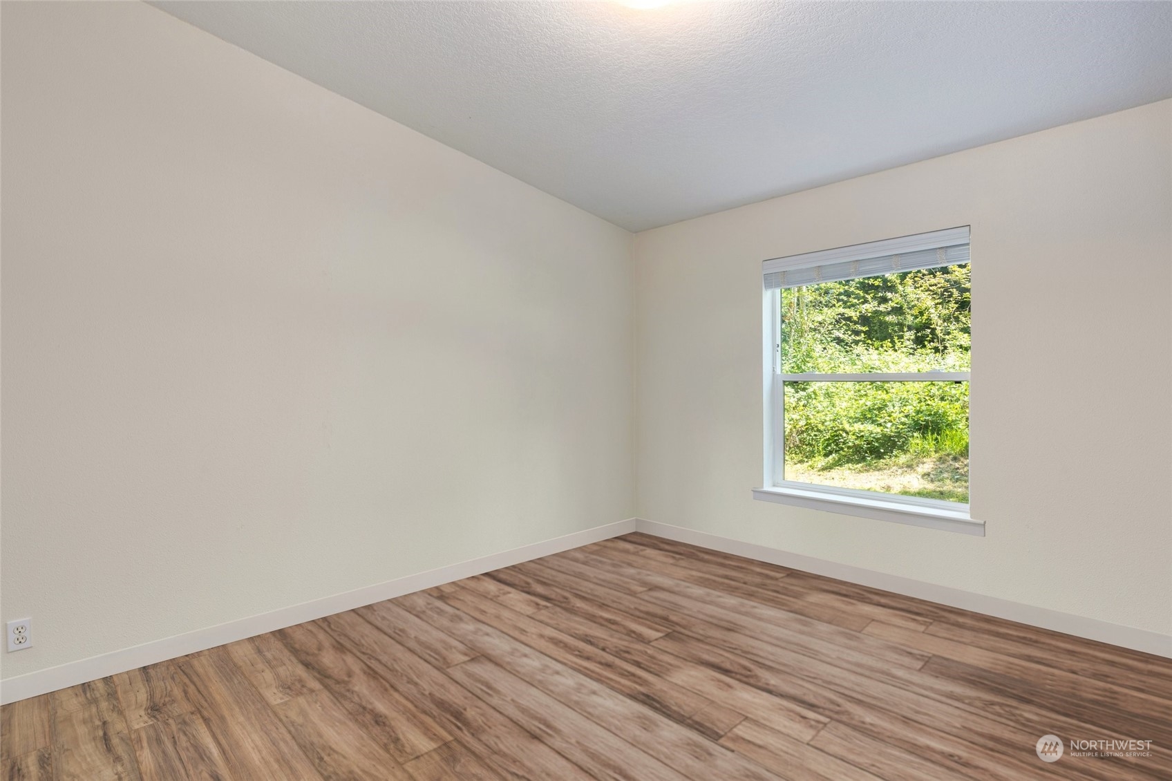 7942 Crockett Road Blaine, WA 98230 - Photo 26 of 33 an empty room with wooden floor and windows