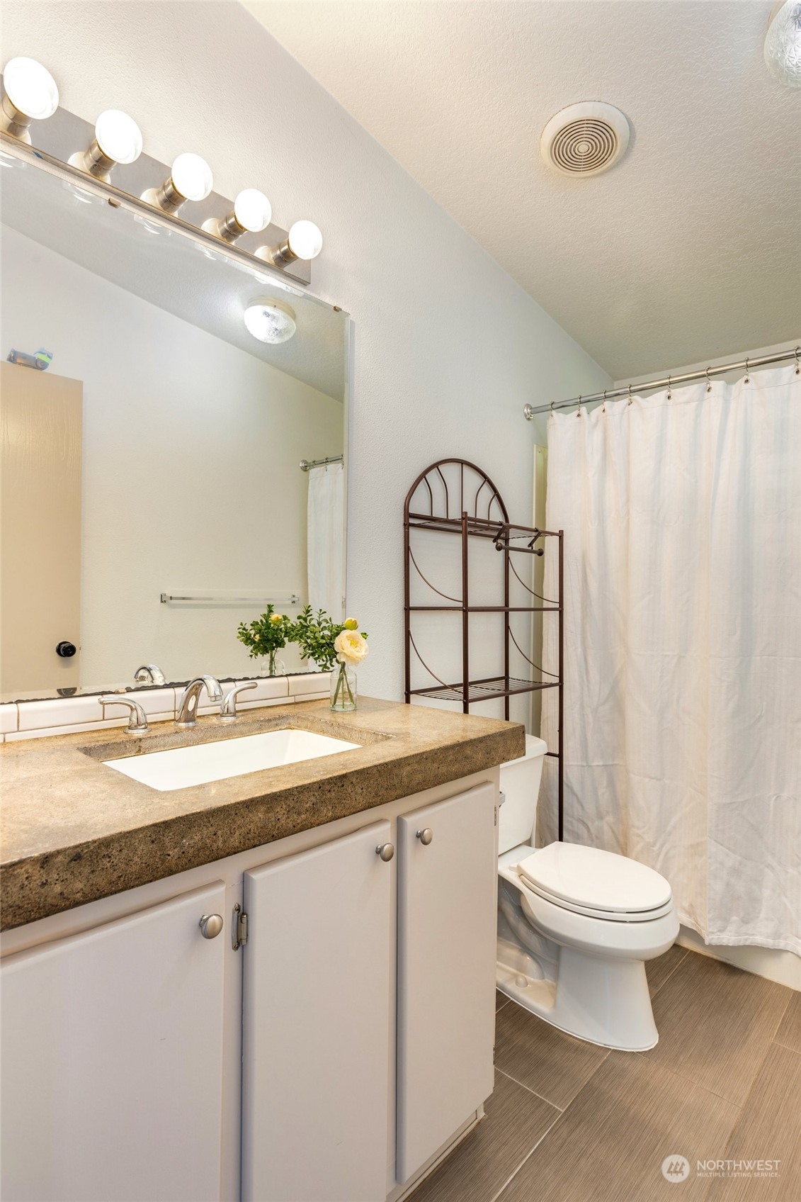 7942 Crockett Road Blaine, WA 98230 - Photo 28 of 33 a bathroom with a granite countertop toilet sink and mirror