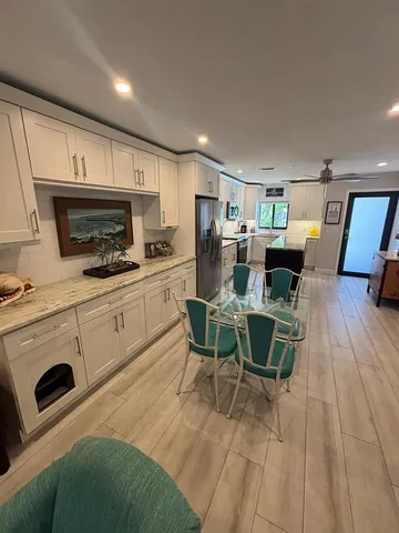 a kitchen with a table chairs microwave and cabinets