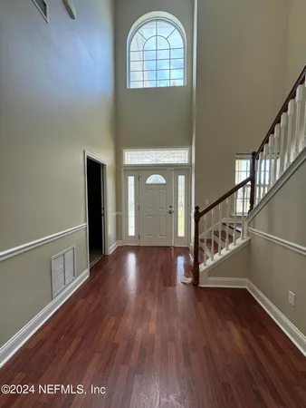 a kitchen with stainless steel appliances granite countertop a refrigerator a sink a stove a microwave and wooden floors