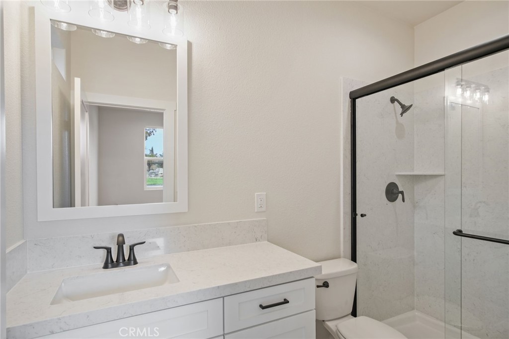 243 East 3rd Street Tracy, CA 95376 - Photo 19 of 29 a bathroom with a sink and mirror with toilet