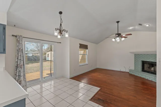 a view of a livingroom with a chandelier fan and windows