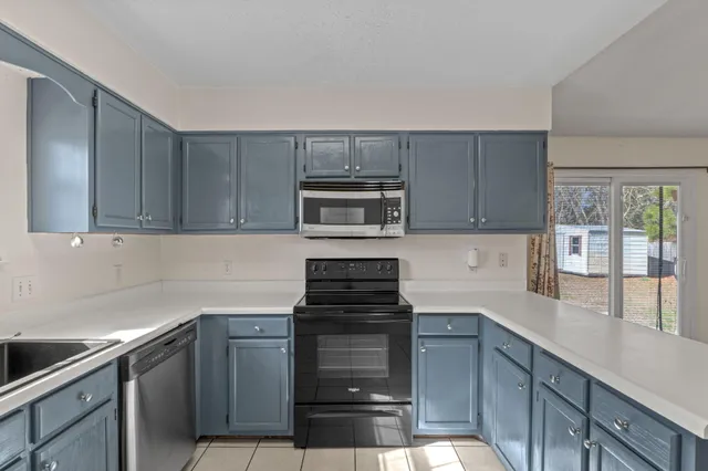 a kitchen with granite countertop white cabinets and stainless steel appliances