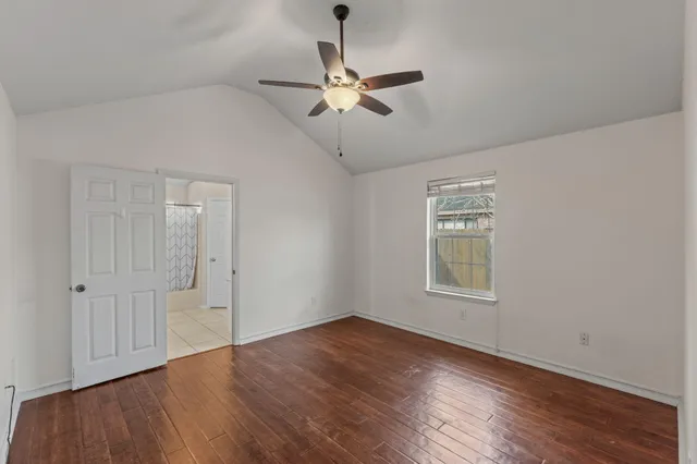 a view of a room with wooden floor and a ceiling fan