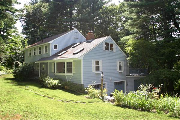 8 Longfellow Road Wayland, MA 01778 - Photo 2 of 24 a front view of a house with a yard and garage