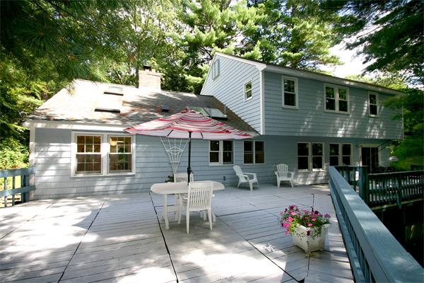 8 Longfellow Road Wayland, MA 01778 - Photo 3 of 24 a patio with a table and chairs under an umbrella