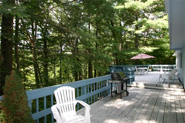 8 Longfellow Road Wayland, MA 01778 - Photo 4 of 24 a view of a chair and tables under an umbrella