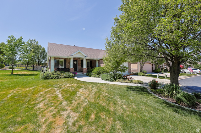 31 Village Square Road Centerville, UT 84014 - Photo 23 of 29 Traditional-style residence featuring a prominent front porch with white columns, dark shutters, and a brick facade accent
