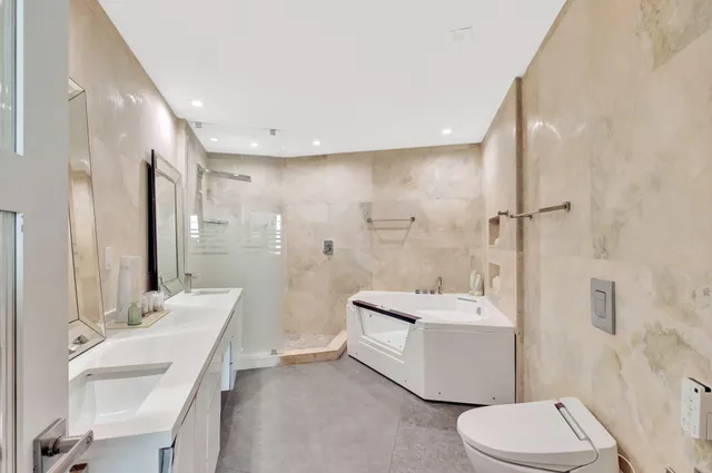 a bathroom with a double vanity sink toilet mirror and shower
