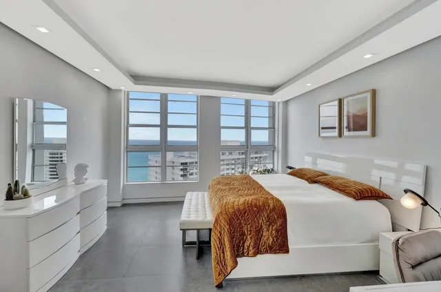 a spacious bedroom with a bed and a large window