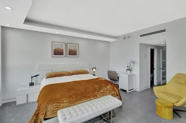 a bedroom with a bed and teddy bear on bed