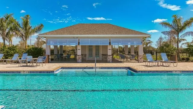 a view of a house with swimming pool and sitting area
