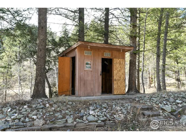 a view of a wooden house with a large tree
