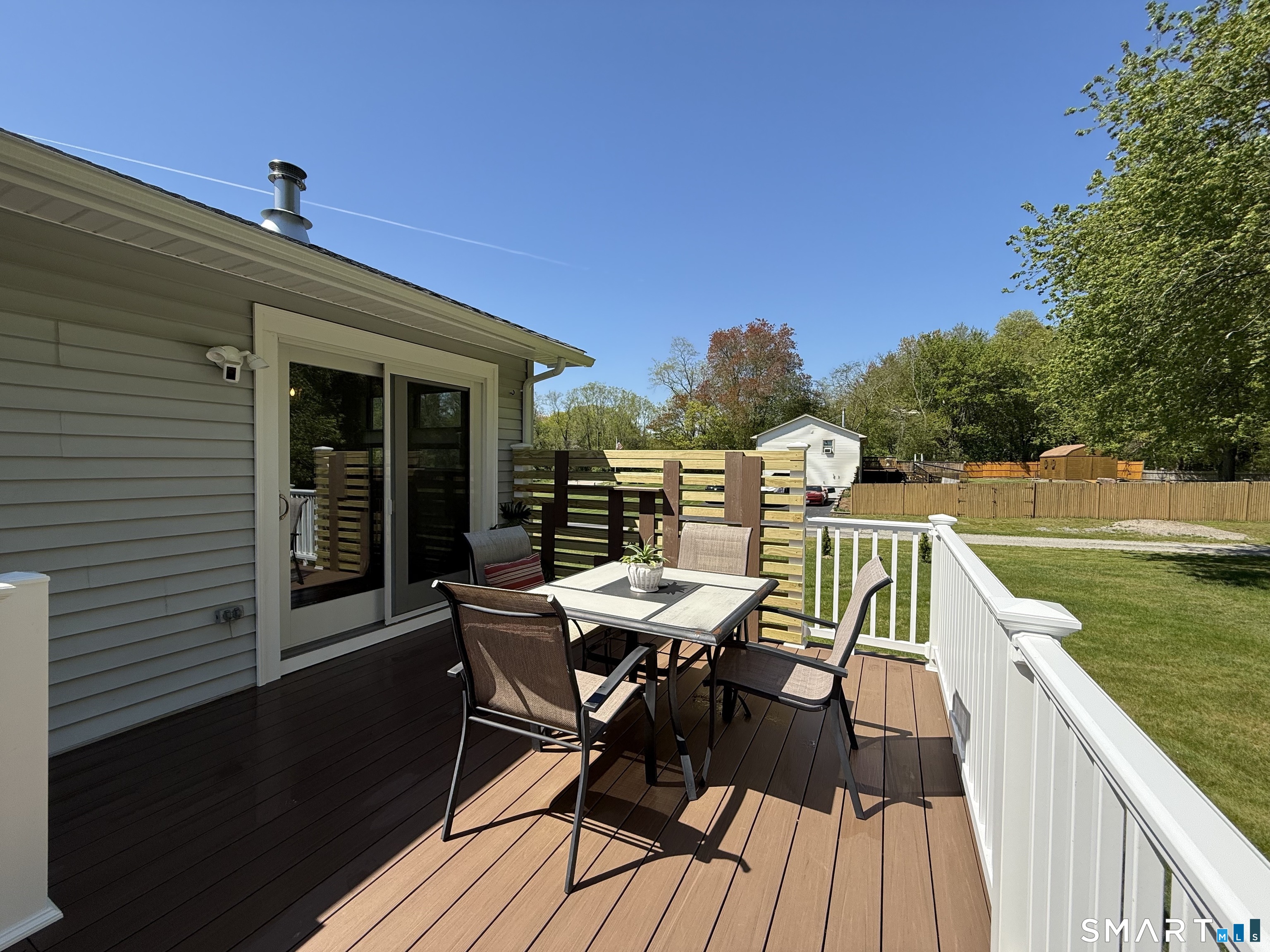 29 Deer Ridge Road Stonington, CT 06378 - Photo 30 of 35 a view of a roof deck with table and chairs with wooden floor and fence
