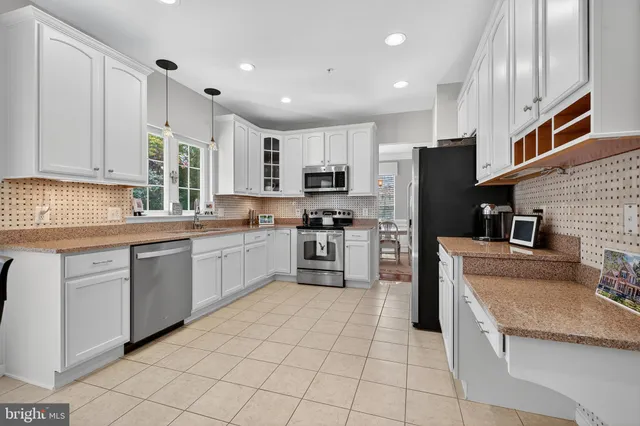 a kitchen with cabinets stainless steel appliances and a counter space