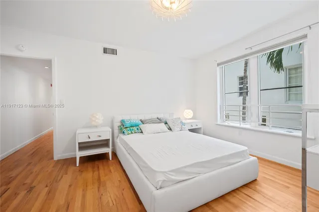 a bedroom with a bed and a large window