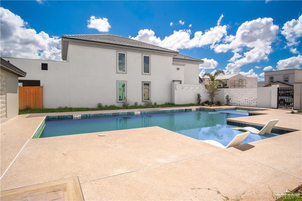 2206 Corales Street Mission, TX 78573 - Photo 20 of 23 Expansive outdoor space featuring a rectangular swimming pool with integrated tanning ledge and in-pool lounge chairs