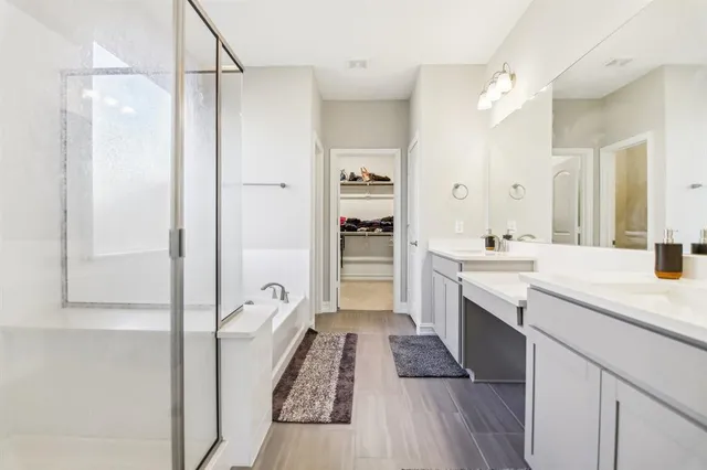 a large white kitchen with a sink dishwasher a refrigerator and cabinets