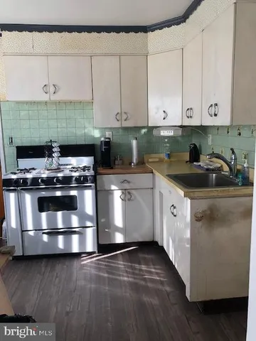 a kitchen with granite countertop a stove sink and cabinets