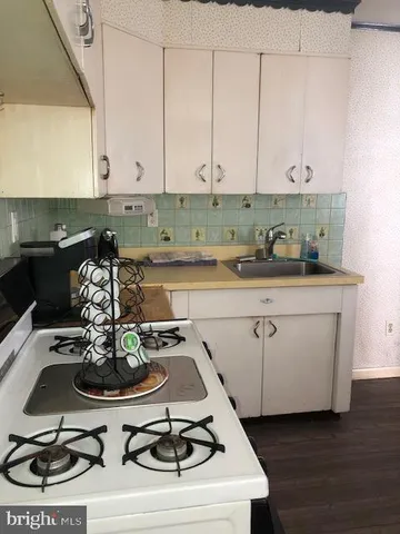 a kitchen with a sink a stove and cabinets