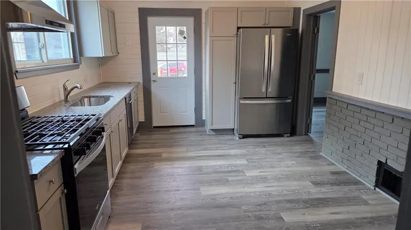 a kitchen with granite countertop a refrigerator and a sink