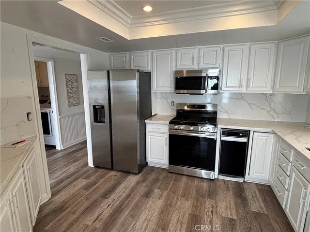 a kitchen with a table chairs refrigerator and cabinets
