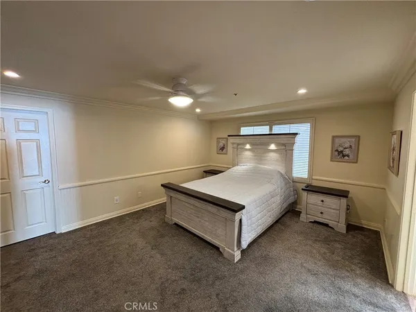 a spacious bedroom with a bed and a flat screen tv