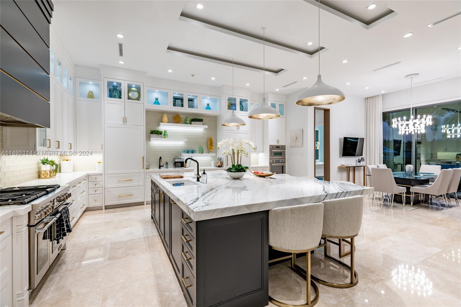 169 West Key Palm Road Boca Raton, FL 33432 - Photo 11 of 27 a open kitchen with stainless steel appliances granite countertop a stove top oven a sink a dining table and chairs with wooden floor