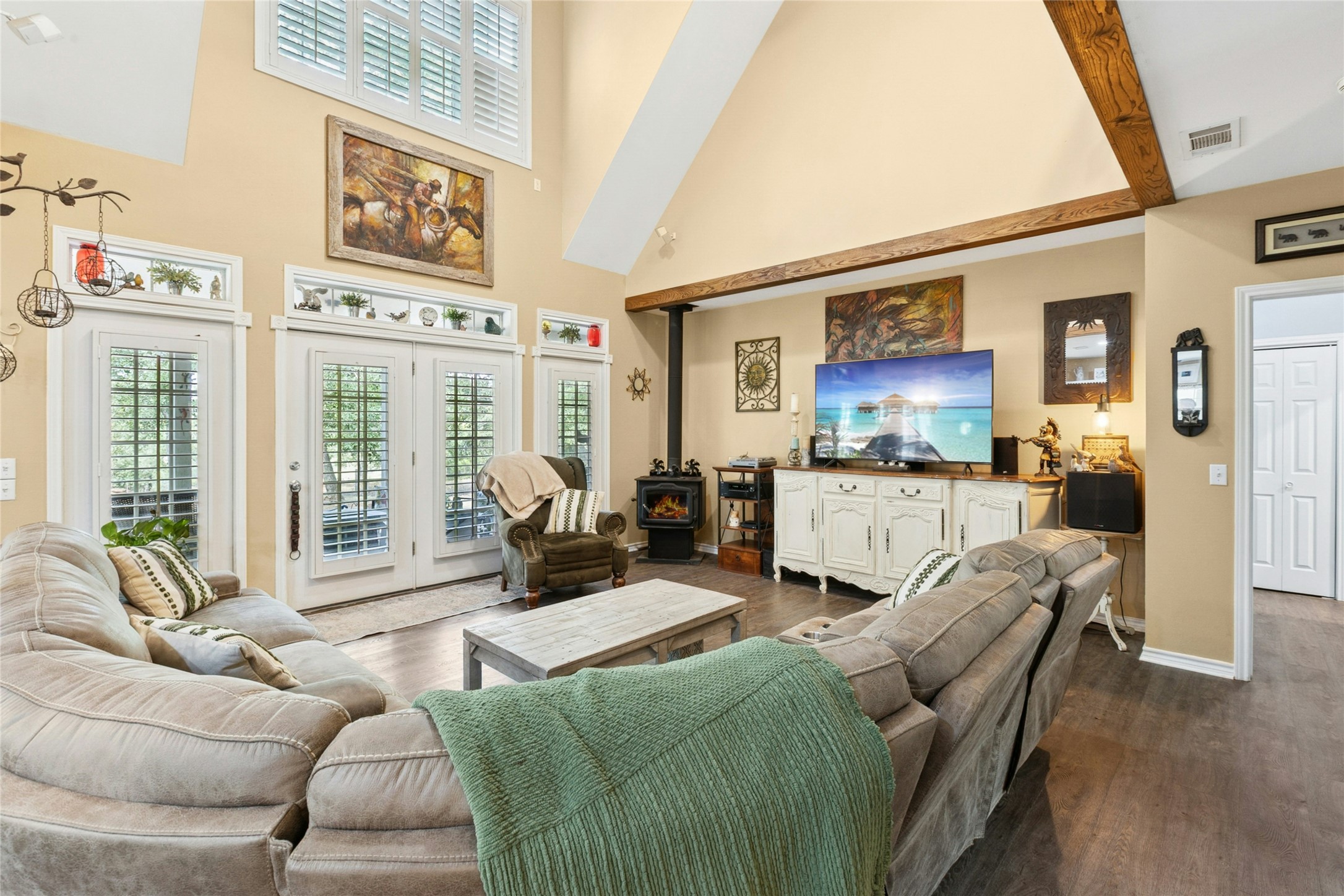412 Woody Hollow Road Luling, TX 78648 - Photo 12 of 33 Living area featuring a wood stove, a towering ceiling, and dark wood-style floors