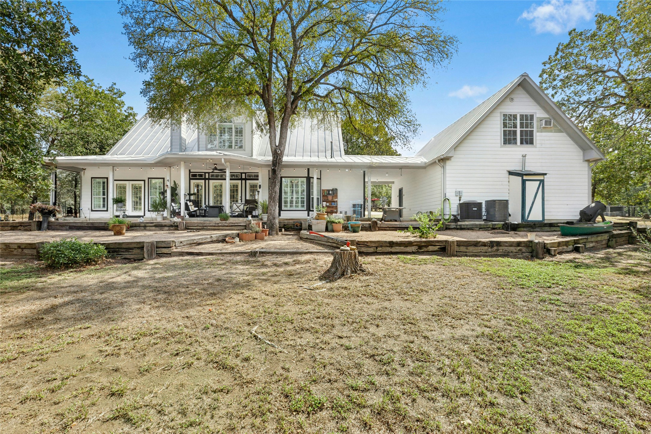 412 Woody Hollow Road Luling, TX 78648 - Photo 6 of 33 Rear view of property with a patio area, a metal roof, a standing seam roof, and a ceiling fan