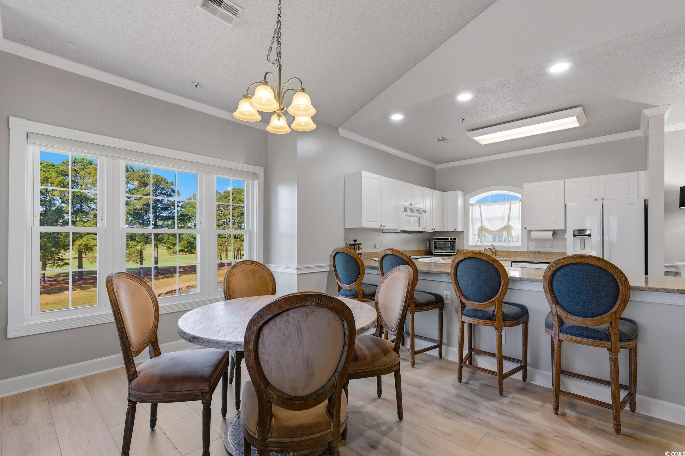 4839 Carnation Circle, Unit 305 Myrtle Beach, SC 29577 - Photo 6 of 24 Dining area featuring crown molding, light wood-type flooring, recessed lighting, a chandelier, and a textured ceiling