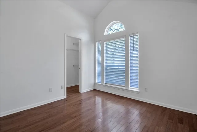 an empty room with chandelier fan and window