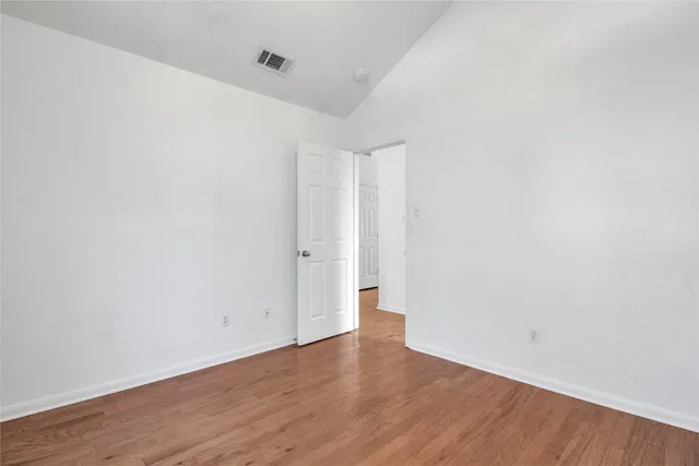 a view of empty room with wooden floor and fireplace