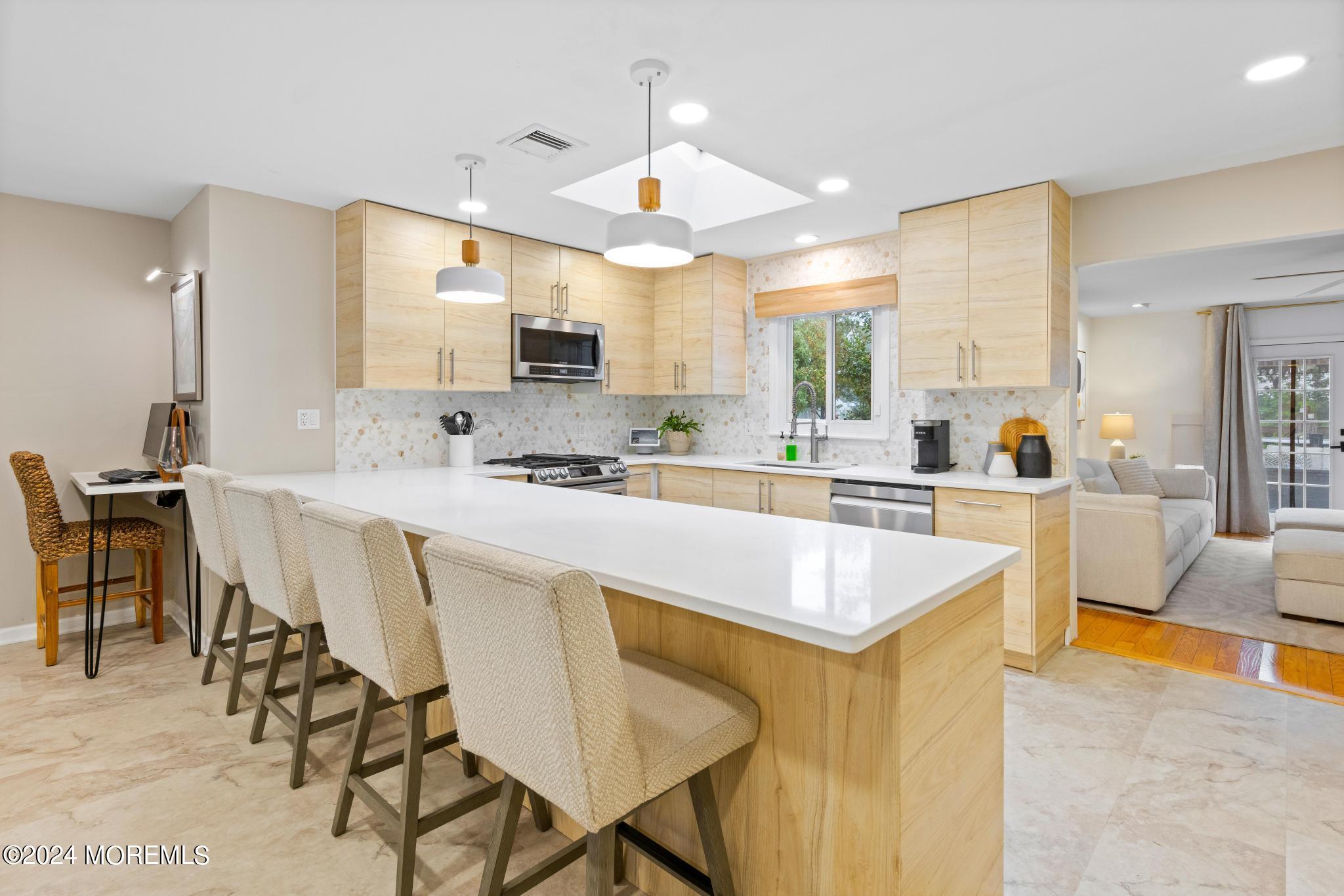 14 Seaton Road Toms River, NJ 08755 - Photo 13 of 59 a large kitchen with kitchen island a large counter top space appliances and a dining table
