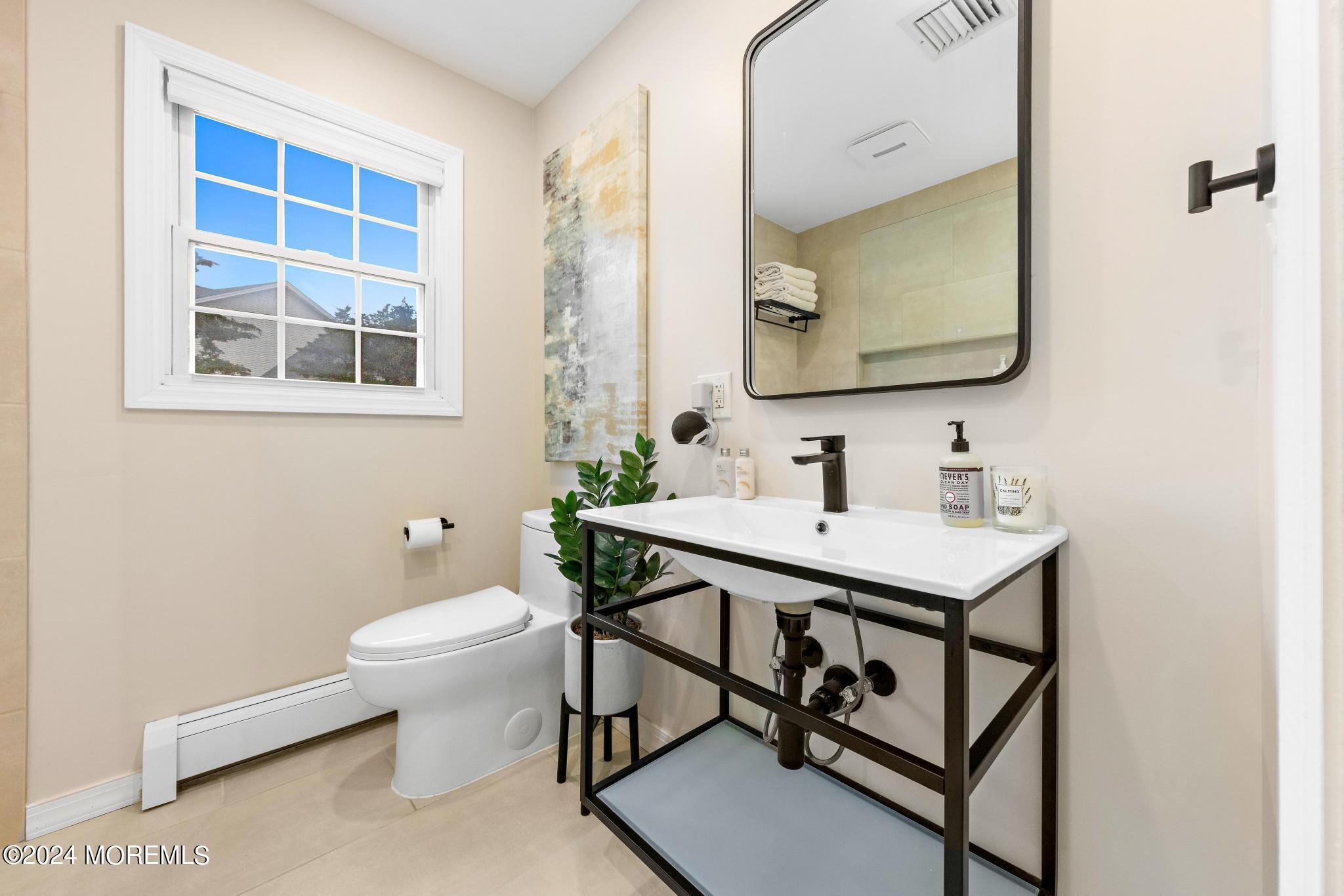 14 Seaton Road Toms River, NJ 08755 - Photo 20 of 59 a bathroom with a toilet a sink and mirror