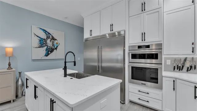 a kitchen with white cabinets and stainless steel appliances