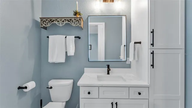 a bathroom with a sink toilet and mirror