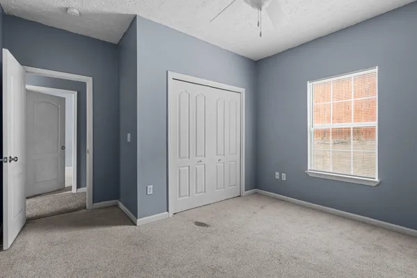 an empty room with windows and closet
