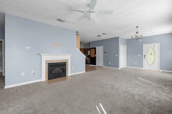 an empty room with a fireplace and fan