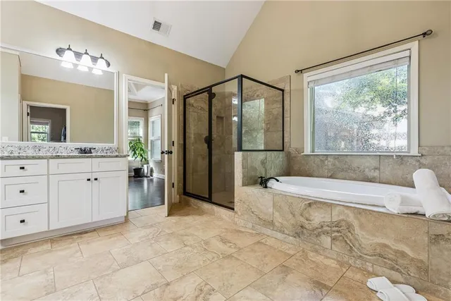 a spacious bathroom with a tub sink and mirror