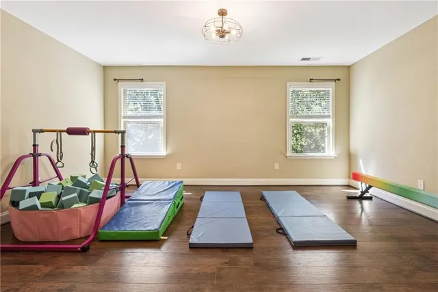 a room with wooden floor and a potted plant