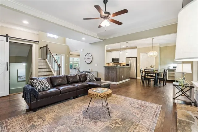 a living room with furniture and a dining table with kitchen view