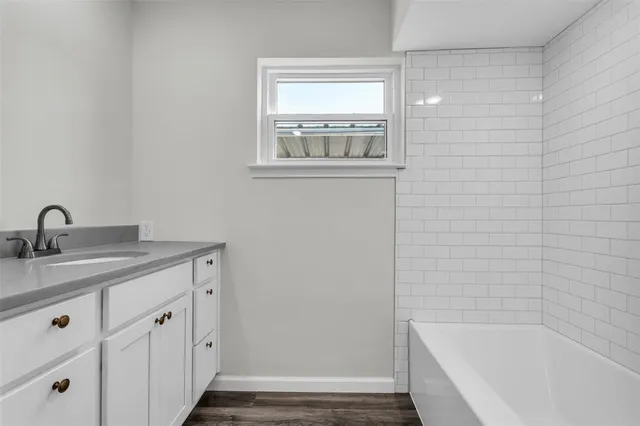 a bathroom with a granite countertop sink and white cabinets
