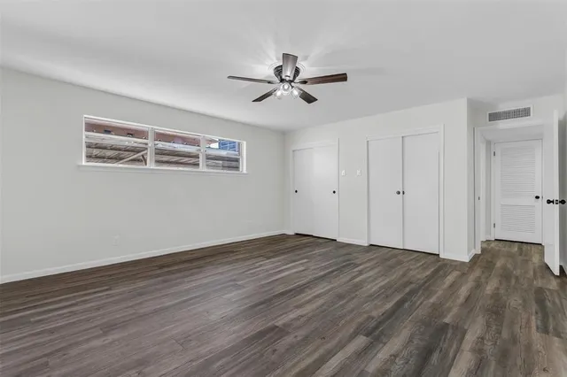 a view of wooden floor and a chandelier fan in a room
