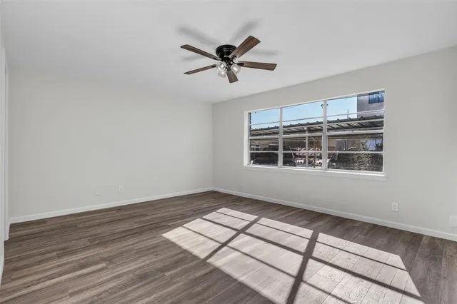 a view of a room with wooden floor and ceiling fan
