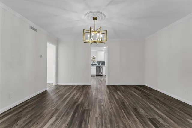 a view of empty room with wooden floor and window