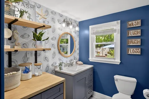 a bathroom with a toilet a sink and a mirror