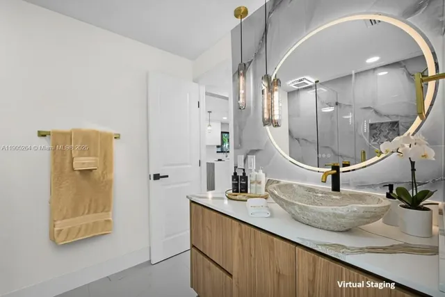 a bedroom with a bed a mirror on dresser and a chandelier