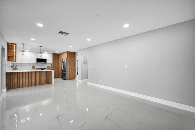 an empty room with wooden floor and window
